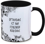 Tasse Totenkopf und Spruch: "Optimismus ist nur fehlender Realismus"